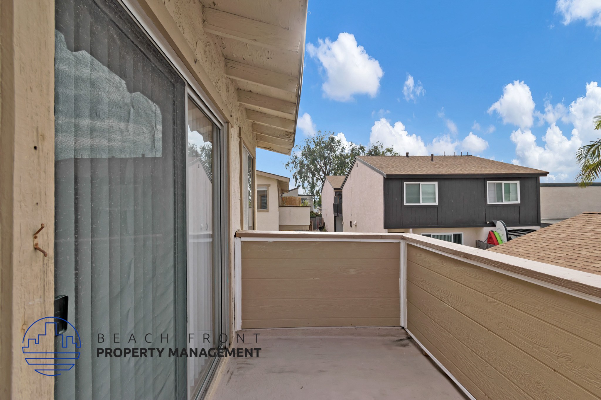 A balcony with a view of the sky and a house.